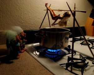 Trolls cooking barbie over a pot