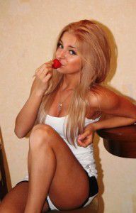 Sucking on a strawberry in her home wear ready to play