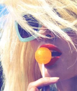 Closeup of blonde with orange lolli