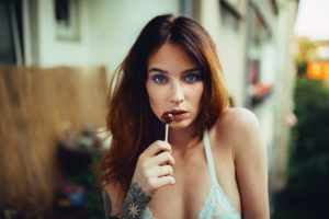 Sexy Redhead with baby blue top and red lollipop